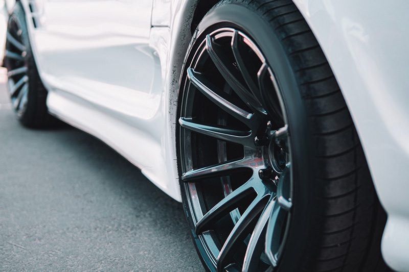 Stylish black wheel on a white car close up